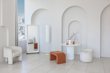 modern pure white interior design of a sprsious sitting room with soft stylish furniture. Large windows frame creating a serene atmosphere during daylight.