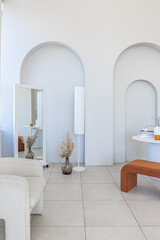 modern pure white interior design of a sprsious sitting room with soft stylish furniture. Large windows frame creating a serene atmosphere during daylight.