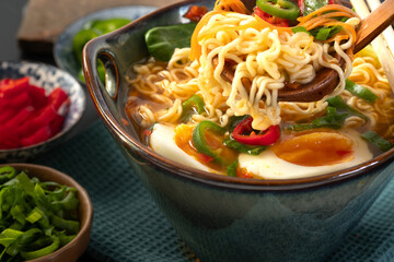 Japanese noodle soup ramen with egg and vegetables in blue ramen bowl