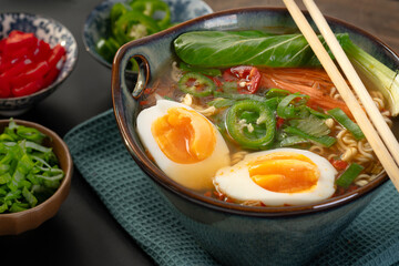 Japanese noodle soup ramen with egg and vegetables in blue ramen bowl