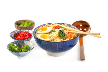 Japanese noodle soup ramen with egg and vegetables in blue ramen bowl on white background