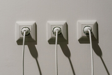 white electrical sockets with plugs in them. connecting high-voltage wire to the socket