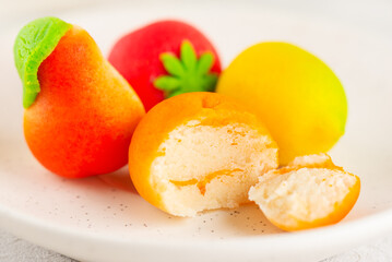 Marzipan candies in the form of fruits: pear, tangerine, lemon and strawberry, closeup.