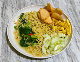 Popular Instant Noodle Soup in Indonesia. Served with Egg, Cucumber, Lettuce, and Chili.