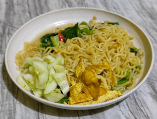 Popular Instant Noodle Soup in Indonesia. Served with Egg, Cucumber, Lettuce, and Chili.