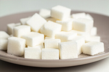 Close up shot of plate with sugar cubes. No sugar concept. Diabetes disease. Obesity. Fast carbohydrates. Health.