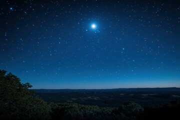 Naklejka premium Starry night sky with a bright glowing moon above a forested landscape