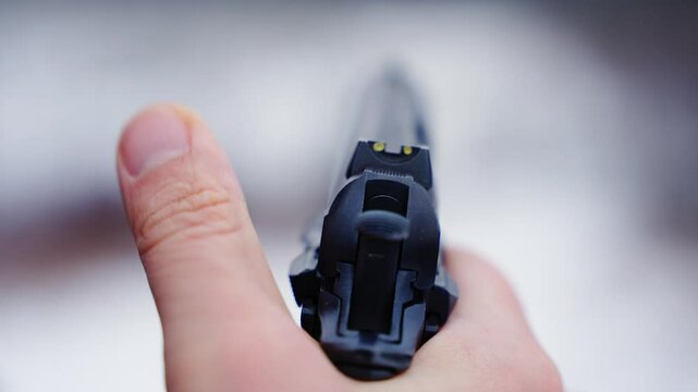 Aiming down the sight of a handgun outdoors, concept of readiness and focus