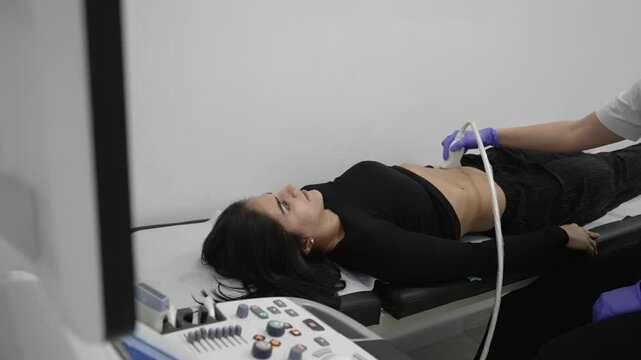 A female patient lays patiently during an abdominal ultrasound.