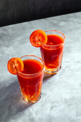 Two refreshing vegetable cocktails. Red cocktail. Tomato juice served in glass with tomato slice. Image for menu, bars, restaurants