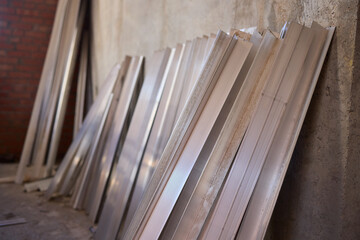 A variety of metal sheets are carefully stacked in a spacious construction area for use