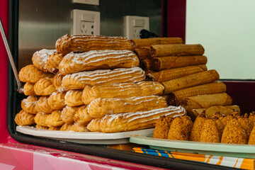 sale of cream eclairs at an amusement park. cheap flour sweets for park guests