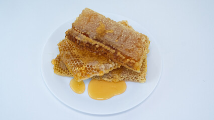 honey flowing over natural honeycombs