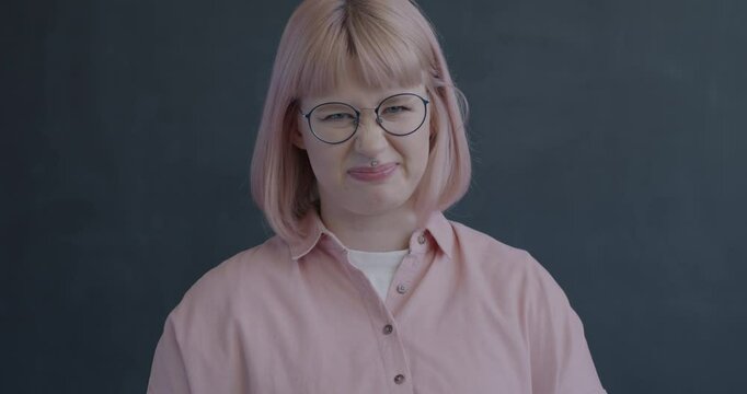 Slow motion portrait of disgusted young woman shaking head refusing on black color background. Negative emotion and face expression concept.