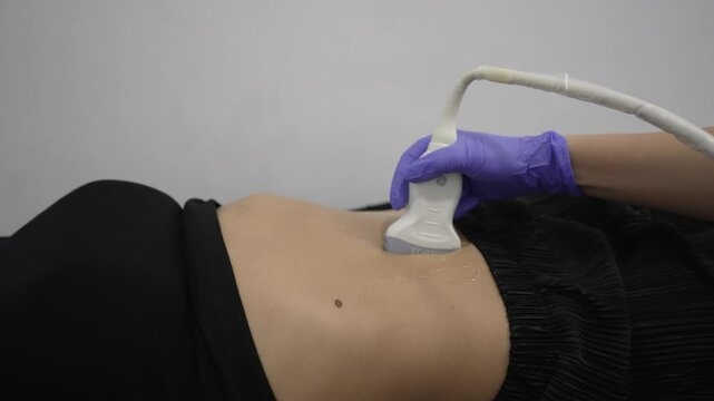 close-up of a female patient's abdomen during an abdominal ultrasound.
