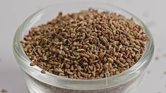 carom seeds or ajwain in small glass bowl, closeup, 4k, parallax shot.