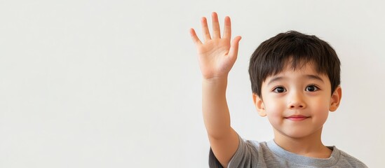 Engaged Young Male Student in Gray Shirt Raising Hand Against Plain White Background for Classroom Conceptual Use