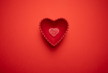Obraz premium Heart-shaped gummy candies in a heart-shaped bowl on a vibrant red background, symbolizing love and romance. Ideal for Valentine's Day, weddings, anniversaries, and romantic celebrations.