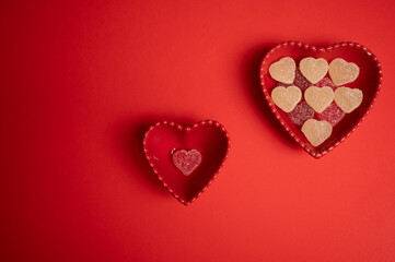 Heart-shaped gummy candies elegantly arranged in a matching heart-shaped bowl on a bold red background. Perfect for Valentine's Day, anniversaries, weddings, and romantic-themed celebrations.