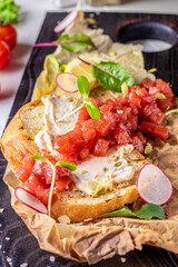 Tuna tartar, bruschetta with cream cheese served on a wooden board