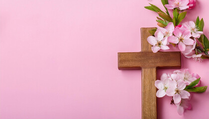 Wooden cross and spring flowers on pink background. Happy Easter. Religion and faith concept.