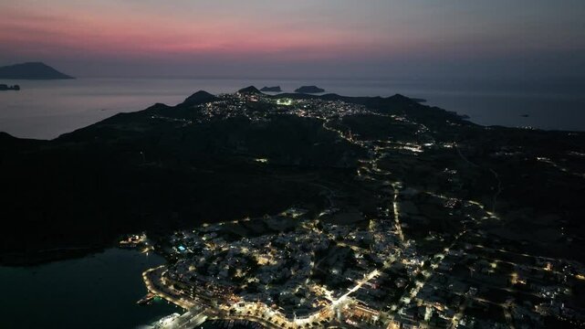 Aerial footage of the island Milos (Melos) in the Aegean Sea, illuminated at night in Greece