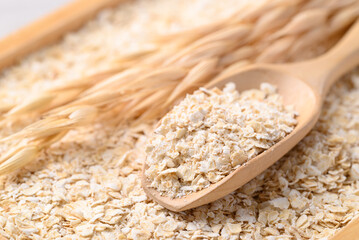 Oat flakes in wooden scoop, Food ingredient in oatmeal, muesli or porridge