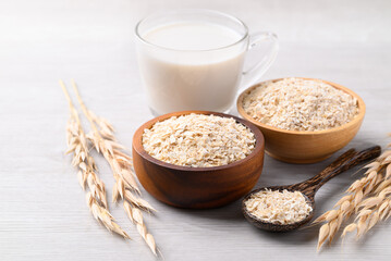 Oat milk in cup glass with oat flakes on white background, Alternative milk made from plant, non dairy
