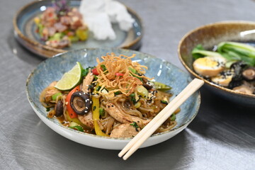 A close-up shot of a healthy, vibrant dish featuring Konjac noodles with tender chicken and a variety of fresh vegetables.