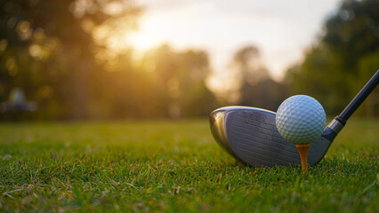 Golf clubs and golf balls on a green lawn in a beautiful golf course with morning sunshine.