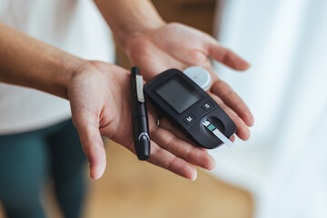 Hands Holding Glucometer and Lancet for Blood Sugar Monitoring