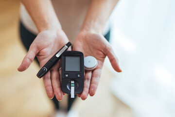 Close-Up of Hands Holding Glucose Meter and Testing Supplies at Home