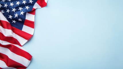 Obraz premium A vibrant American flag drapes over a soft blue background, symbolizing patriotism and national pride.