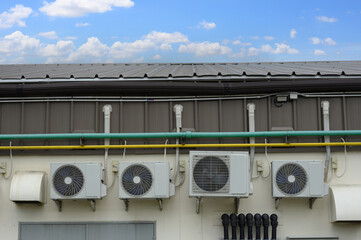 Air compressor or air condenser unit located on support outside building to heat released...