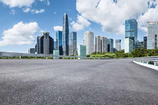Empty asphalt road and modern city skyline with blue sky background - Powered by Adobe