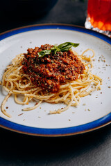 Spaghetti bolognese garnished with basil and herbs, a perfect Italian business lunch meal