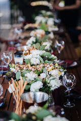 Luxurious dining table setup with flowers, appetizers, and wine glasses for an elegant celebration
