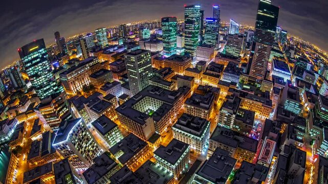 Nighttime warsaw cityscape revealing illuminated downtown buildings and streets from aerial fisheye perspective, capturing urban landscape with radiant metropolitan energy
