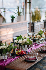 Elegant outdoor table setup with fresh fruit, flowers, and glassware for a festive gathering