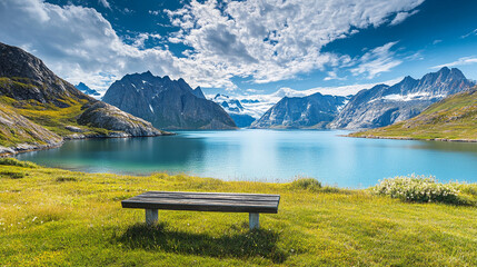 Mountain lake with a wooden bench, surrounded by rocky peaks and clear blue sky