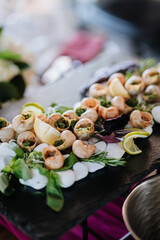 Gourmet escargot platter with fresh herbs and lemon, elegantly presented on a slate serving board