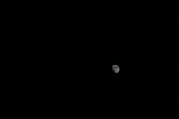 A captivating view of a waxing moon in the dark night sky. The image showcases the moon’s...