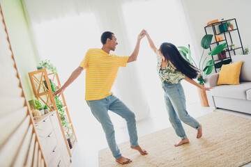 Photo of funny positive multinational couple have fun enjoy weekend relax rest dance indoors flat