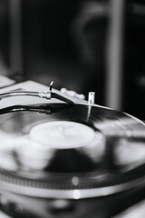 Obraz premium Black and white close-up of a vinyl record on a turntable, evoking timeless music and retro vibes