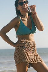 Lating woman on the beach wearing a crochet skirt