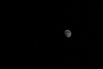 A captivating view of a waxing moon in the dark night sky. The image showcases the moon’s...