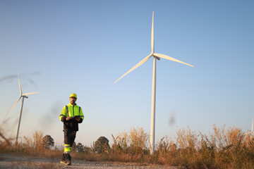 Wind turbine engineer at a wind farm in a field under a clear blue sky