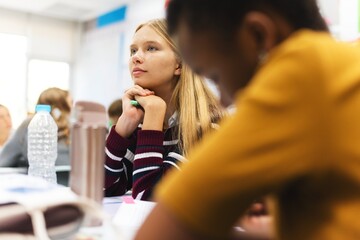 Students in a classroom setting, focused on learning. Diverse group of students, engaged in study. Classroom environment with attentive students. Education and knowledge.
