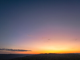 .aerial view A beautiful sunset paints the sky in vivid shades of orange .and red over a deciduous forest..Colorful leaves when the season comes to bloom in the big forest.