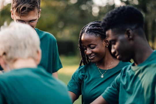 Group of diverse volunteers standing together in a park